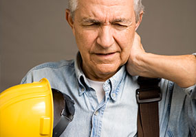 Construction worker with his hand on his neck in pain